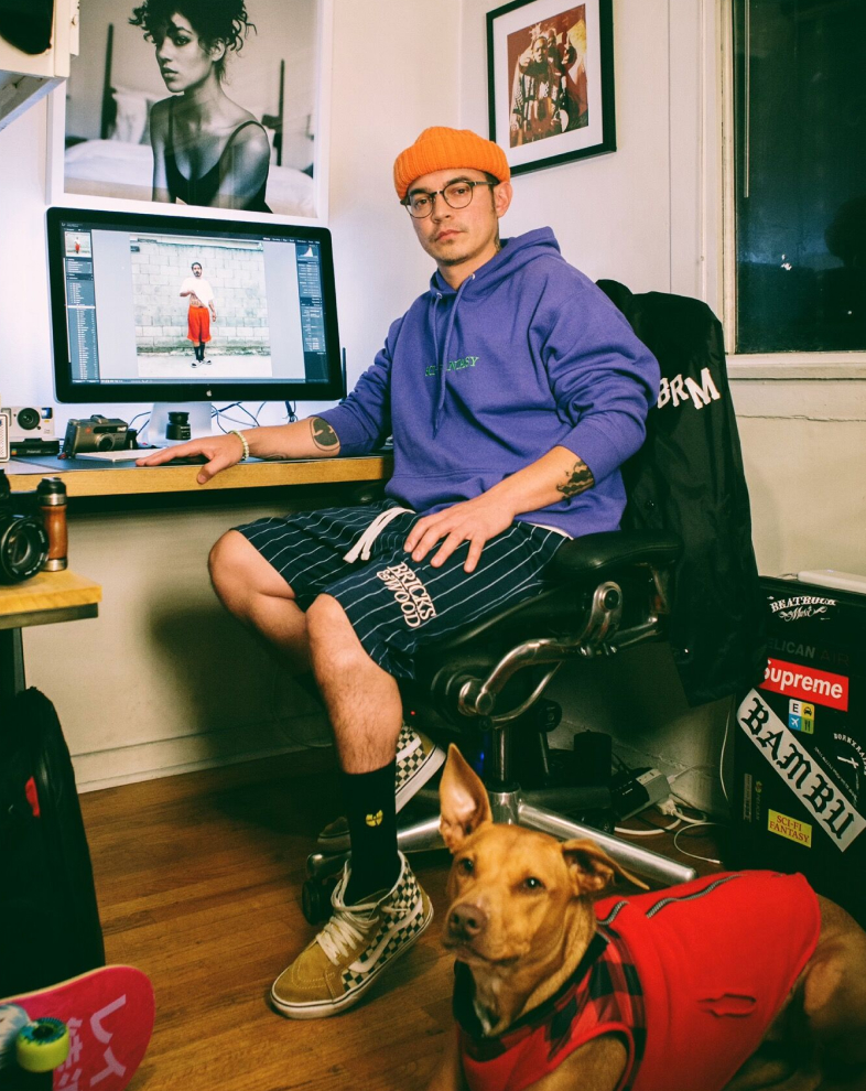 Photographer editing pictures in his office, accompanied by his dog