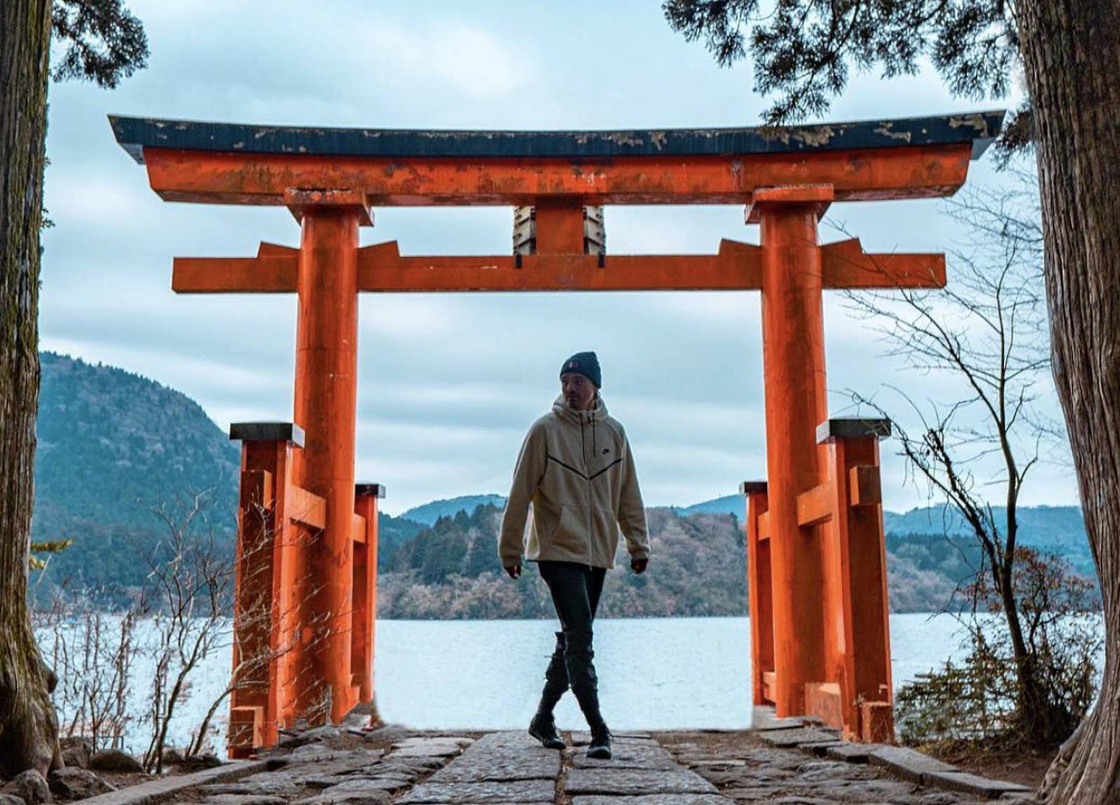 Dean Unglert under a Torii gate in front of a lake